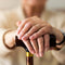 lady with her hands on walking stick senior living aids