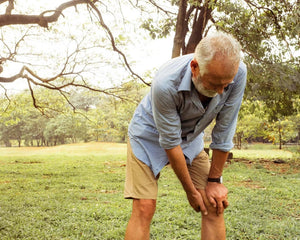 older man holding his injured knee