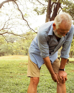 older man holding his injured knee
