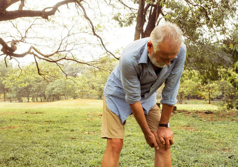 older man holding his injured knee
