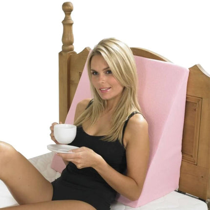 Woman relaxing in bed with Harley Bed Relaxer, enjoying coffee and a snack for comfort and support.