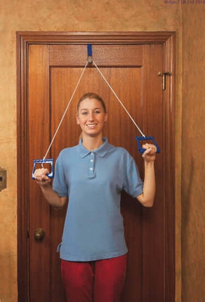 Woman demonstrating Over Door Exercise Pulley for shoulder rehabilitation in a home setting.