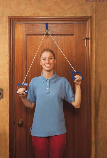 Woman demonstrating Over Door Exercise Pulley for shoulder rehabilitation in a home setting.
