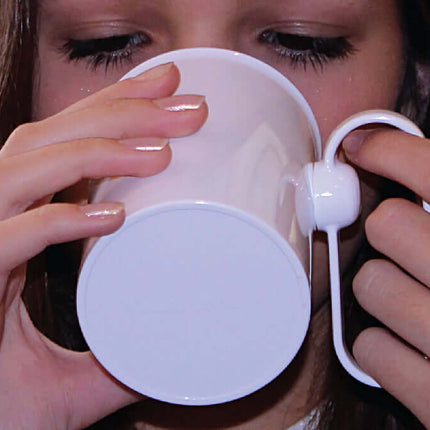 Girl using HANDSTEADY drinking aid to hold a cup, demonstrating steady grip for easy drinking.