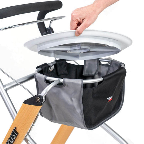 Hand adjusting the removable tray on the Let's Go Indoor rollator, showcasing the convenient storage underneath.