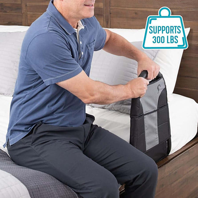 Man using Stander Bedside Econorail shown to support up to 300 lbs, demonstrating its ease of use and practicality.
