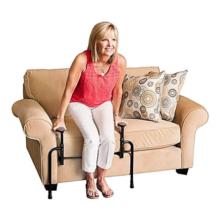 Woman using EZ Stand N Go for support while standing from a sofa, demonstrating adjustable handles.
