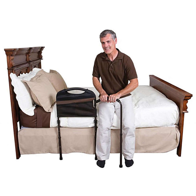 Man using Stander Mobility Bed Rail for support while sitting on a bed, promoting stability and safety.