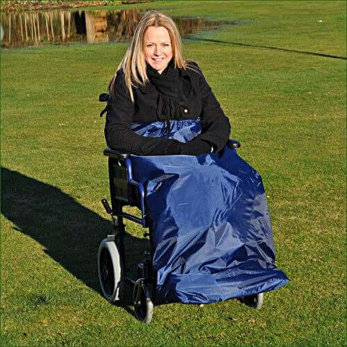 Woman in a wheelchair wearing a blue Splash Deluxe Wheelchair Apron, highlighting comfort and waterproof design.